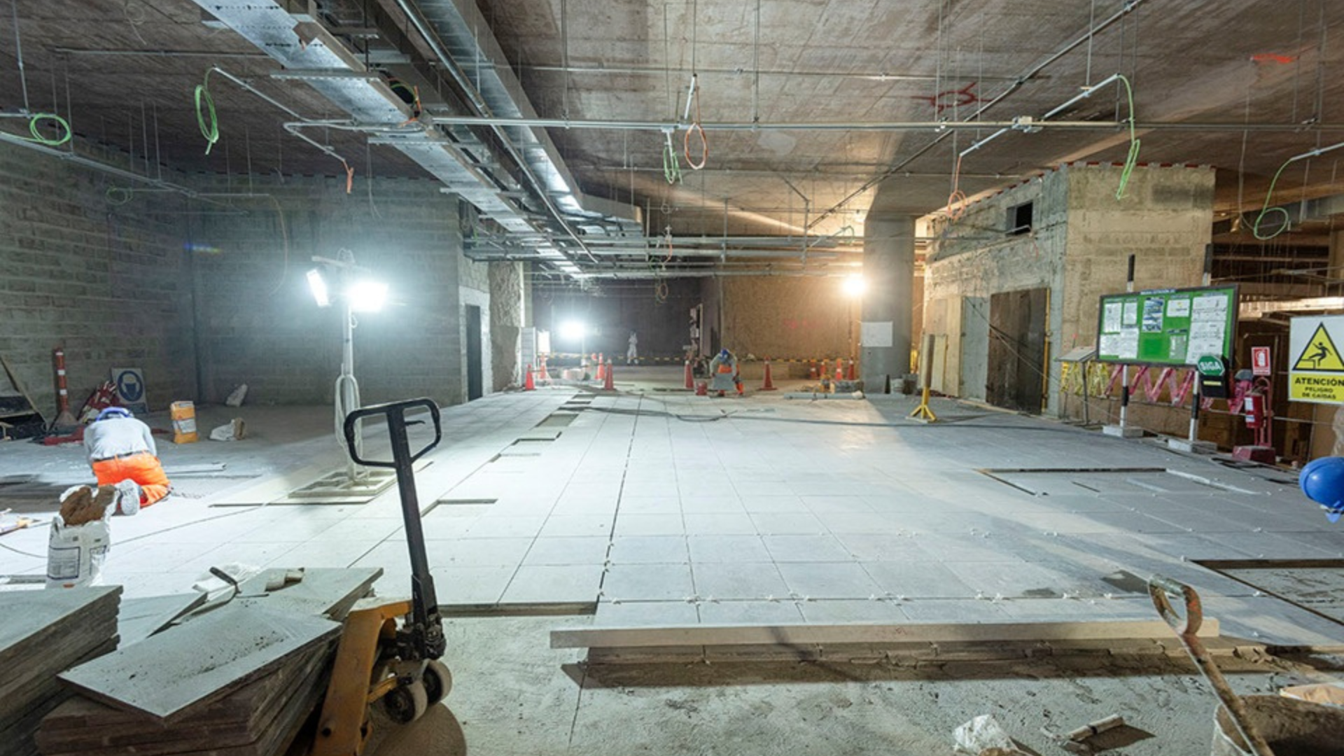 Interior construction site with exposed concrete, MEP installations and floor preparation