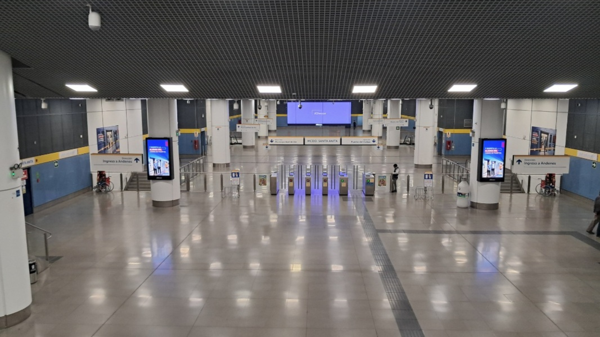 Modern metro station concourse with turnstiles and passenger access area
