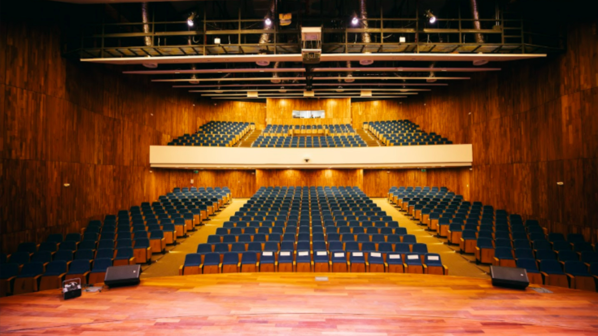 Large auditorium interior with stage and tiered seating